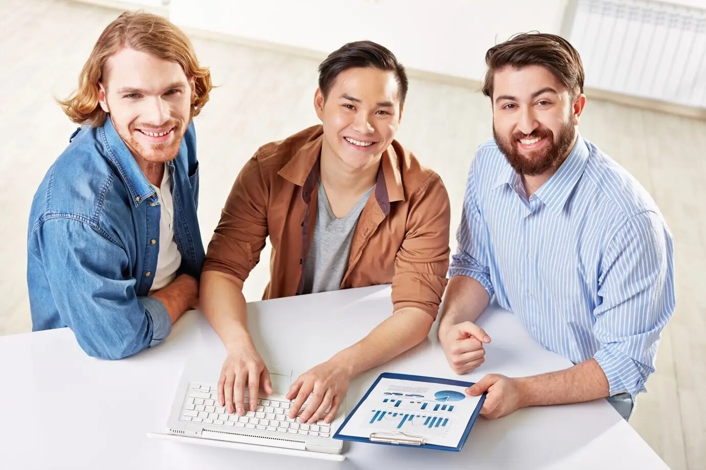 Intelligente Mitarbeiter nutzen bei einem Meeting einen Laptop.